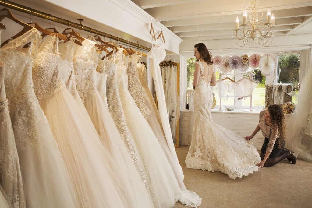 Rows of wedding dresses on display in a specialist wedding dress shop.