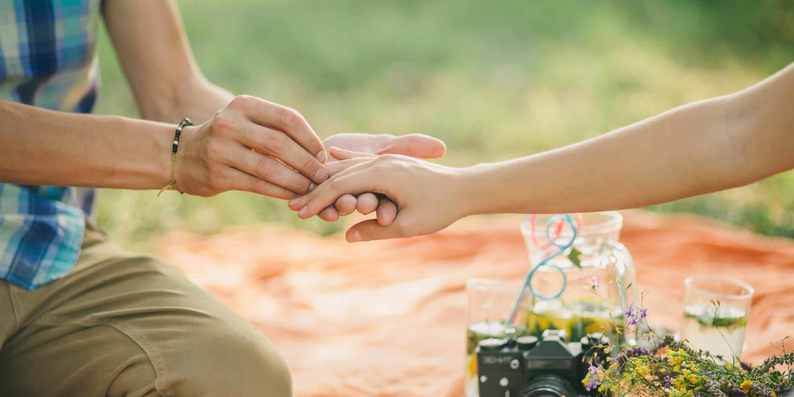 engagement ring proposal hands close up in picnic