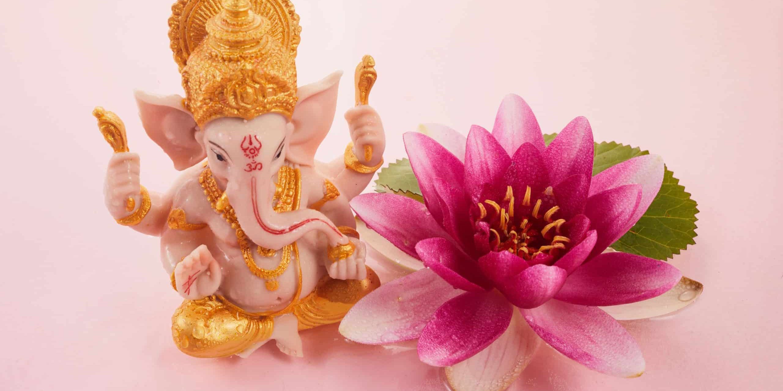 Der hinduistische Gott Ganesha links neben einer lilafarbenen Wasserlilie