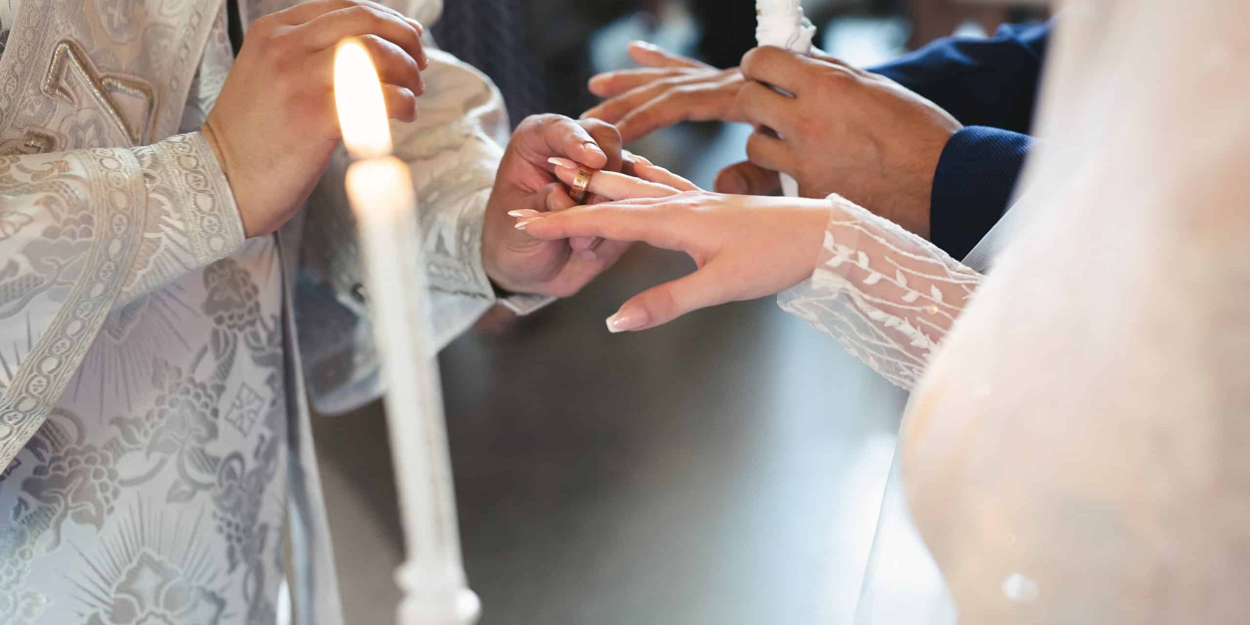 The priest consecrates the wedding rings on the fingers of the bride and groom. Wedding tradition and ritual. hands of a young couple in the church.